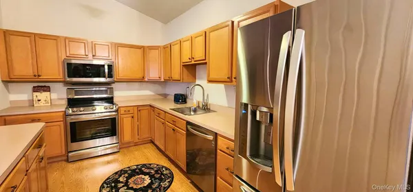 a kitchen with stainless steel appliances granite countertop a refrigerator a stove top oven a sink and dishwasher