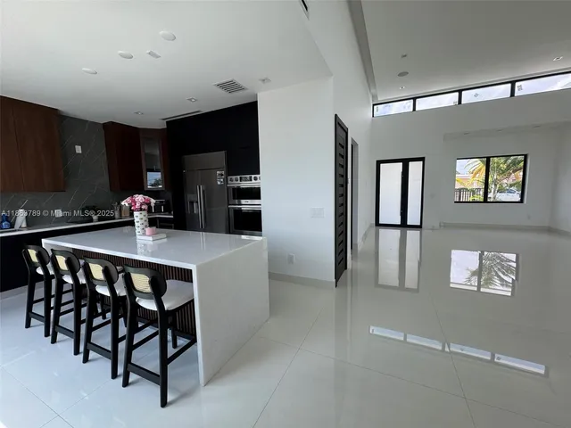a kitchen with a table chairs refrigerator and microwave