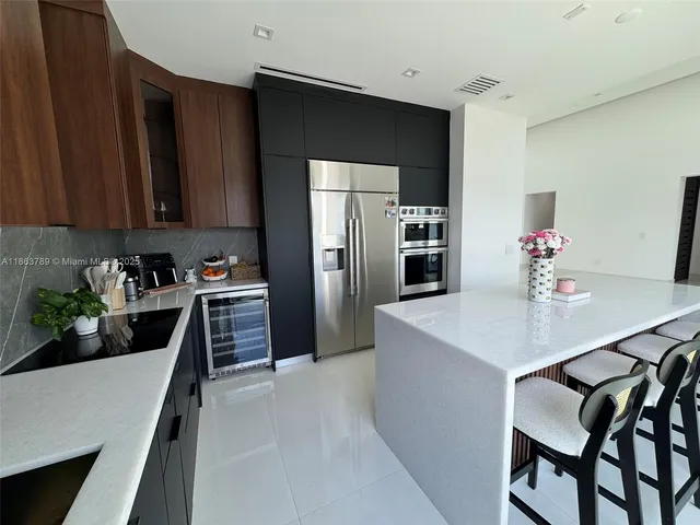 a kitchen with granite countertop a refrigerator stove and sink