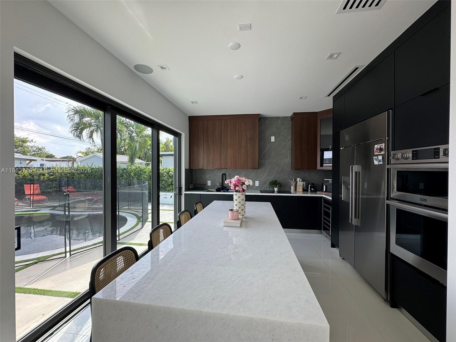 10960 Southwest 42nd Terrace Miami, FL 33165 - Photo 21 of 38 a kitchen with stainless steel appliances a sink window and a refrigerator