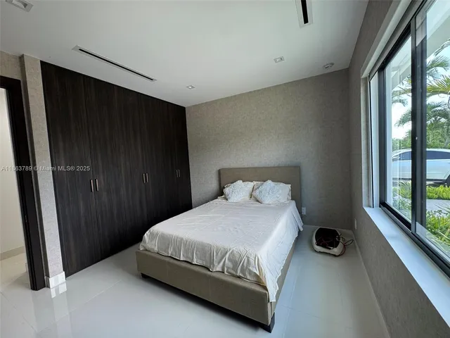 a bedroom with a bed and a large window