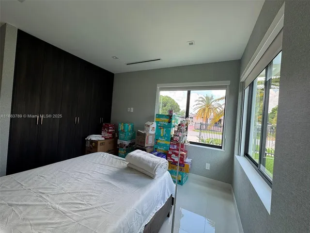 a bedroom with a bed and a large window