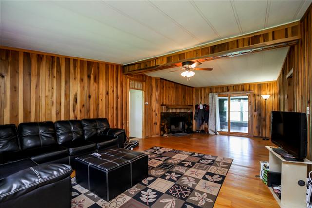 6291 Ladd Road Franklin, TN 37067 - Photo 17 of 20 Large living room with a wood burning fireplace and door going out to the back enclosed porch.