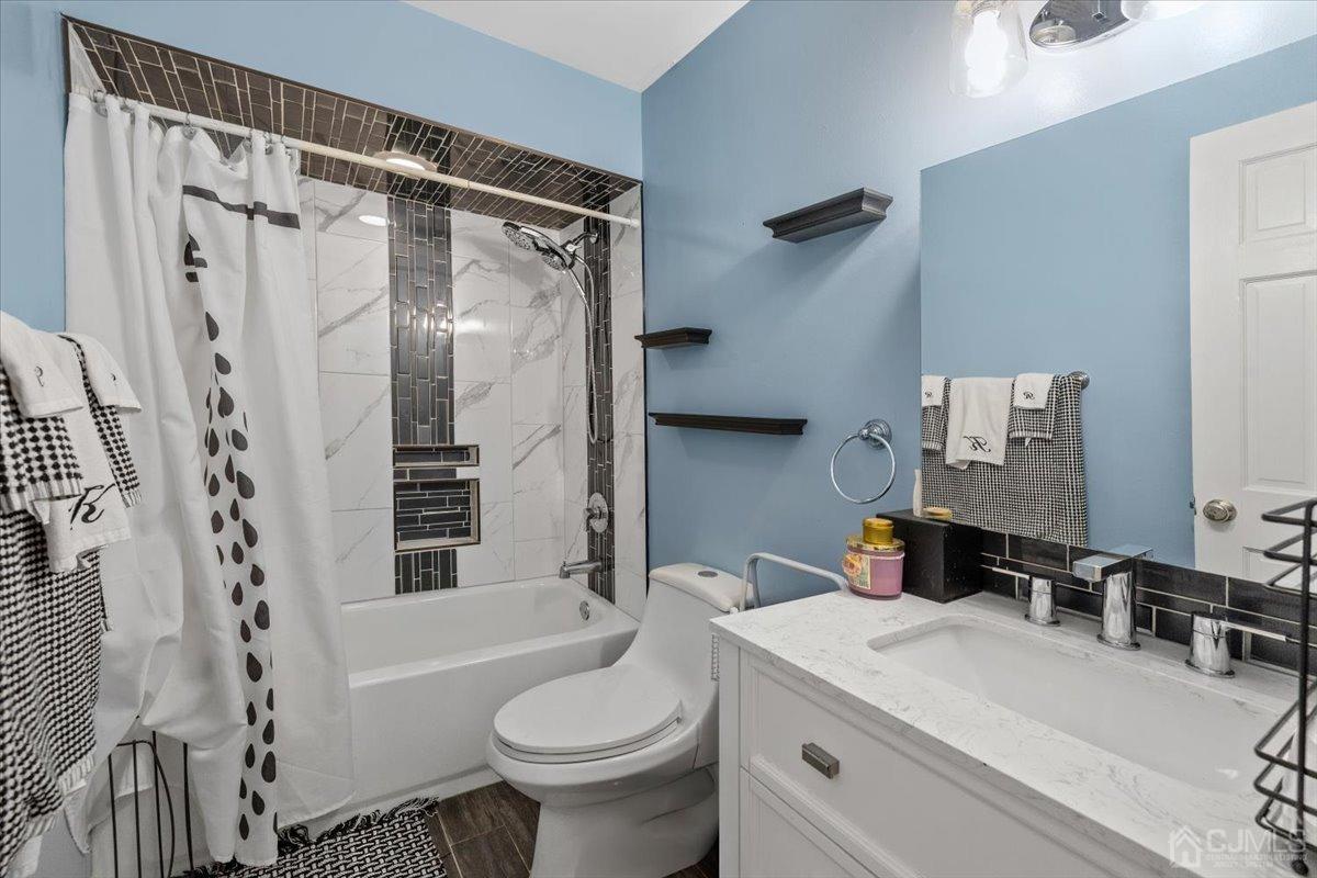 15 Drake Road Somerset, NJ 08873 - Photo 15 of 27 a bathroom with a sink a toilet a mirror and shower
