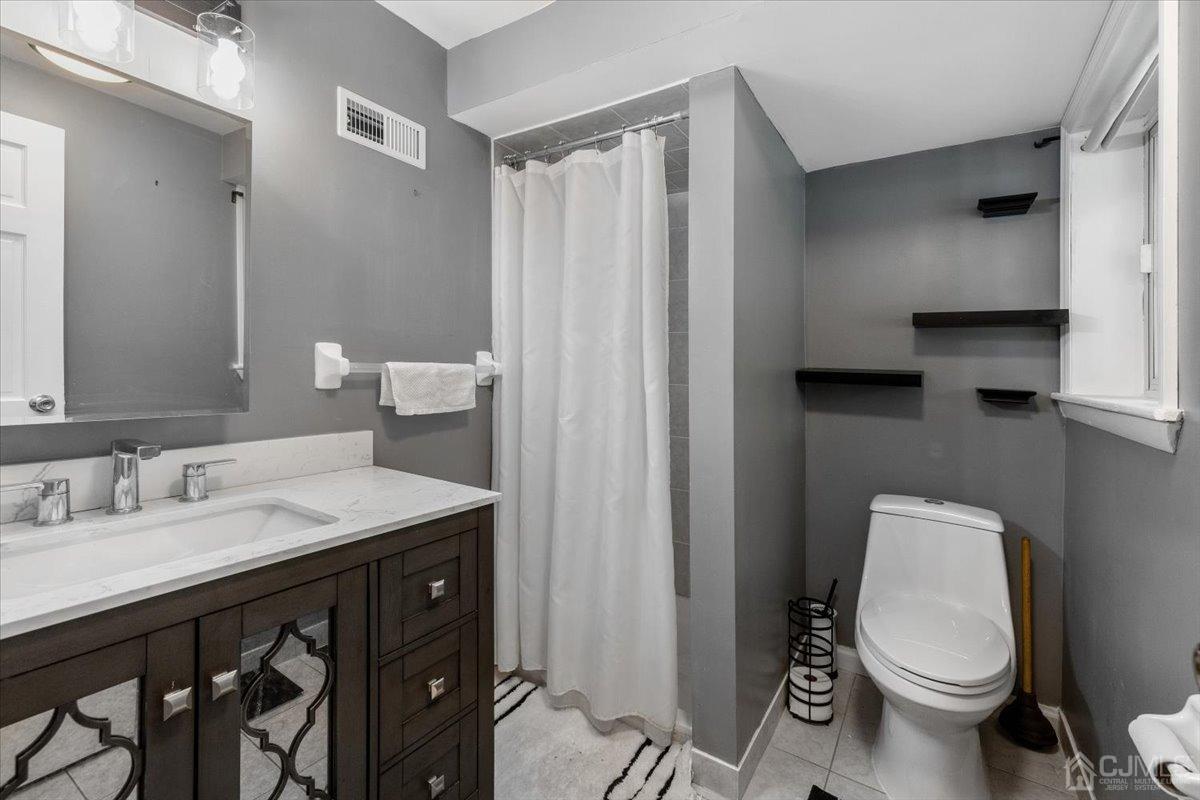 15 Drake Road Somerset, NJ 08873 - Photo 18 of 27 a bathroom with a toilet a sink and a mirror
