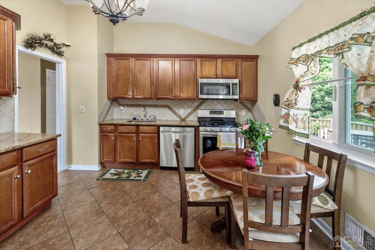 15 Drake Road Somerset, NJ 08873 - Photo 10 of 27 a kitchen with a stove a table and chairs in it