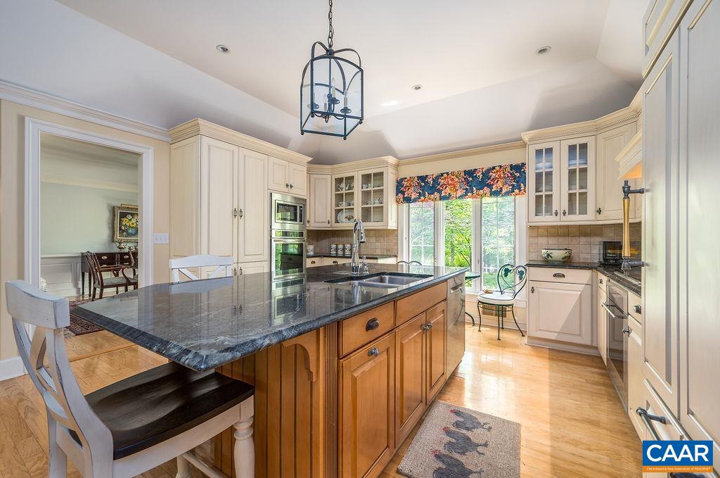 960 Windsor Road Charlottesville, VA 22901 - Photo 14 of 51 a kitchen with stainless steel appliances granite countertop a stove top oven a sink dishwasher a dining table and chairs with wooden floor