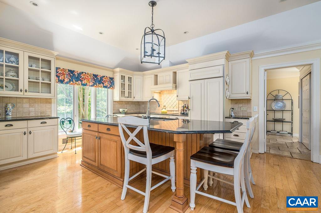 960 Windsor Road Charlottesville, VA 22901 - Photo 15 of 51 a kitchen with stainless steel appliances granite countertop a stove a refrigerator a sink a dining table and chairs with wooden floor