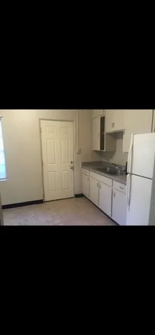 a view of kitchen with stainless steel appliances a sink and a refrigerator