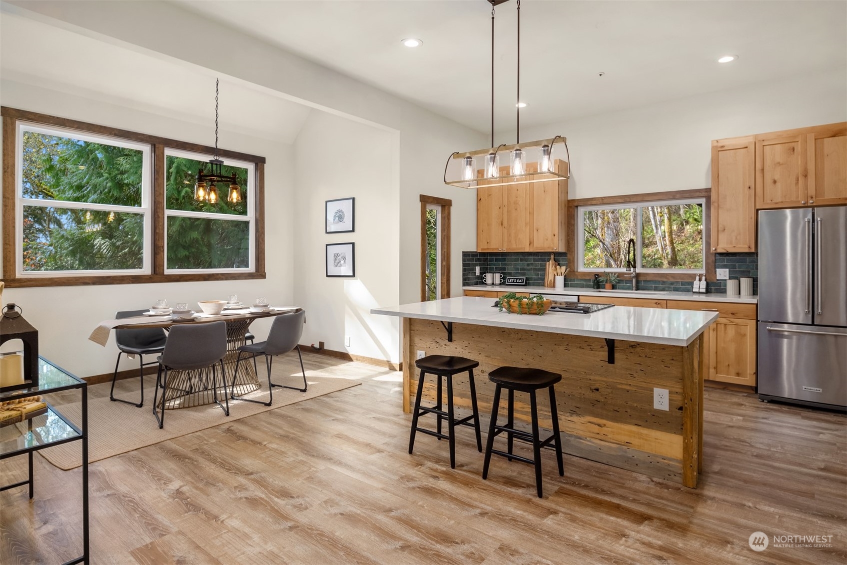 17548 Southeast 110th Street Renton, WA 98059 - Photo 7 of 37 a kitchen with stainless steel appliances granite countertop a stove a refrigerator a oven a sink a dining table and chairs with wooden floor