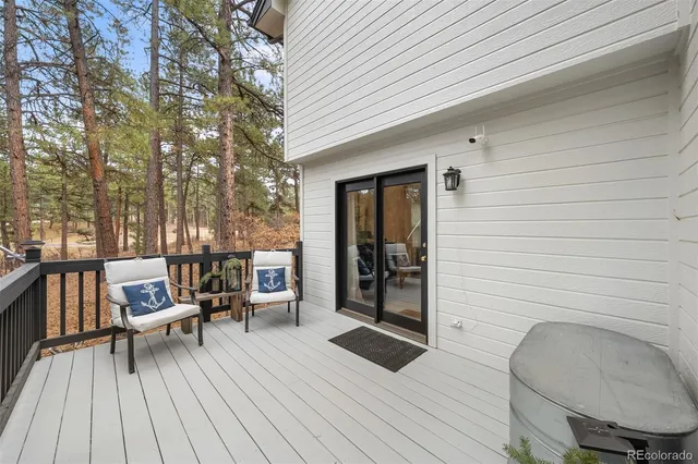 a balcony with wooden floor table and chairs