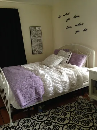 a bedroom with a bed and a wall painting