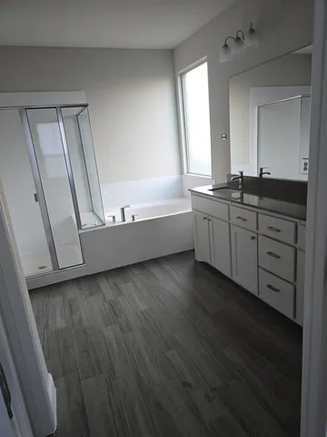 a bathroom with a granite countertop sink a mirror and a bathtub