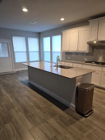 a kitchen with stainless steel appliances granite countertop a stove a sink and a microwave