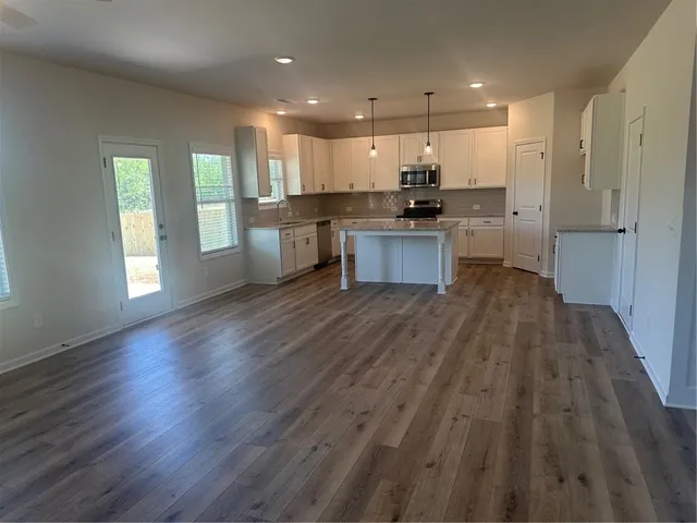 a view of kitchen with wooden floor and electronic appliances