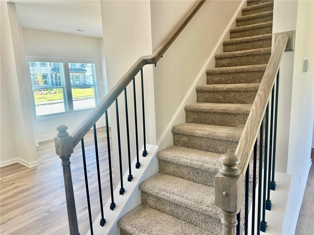 325 Rodeo Drive Auburn, GA 30011 - Photo 9 of 39 a view of staircase with wooden floor and white walls