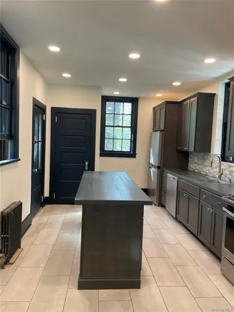 a kitchen with stainless steel appliances granite countertop a sink and a refrigerator