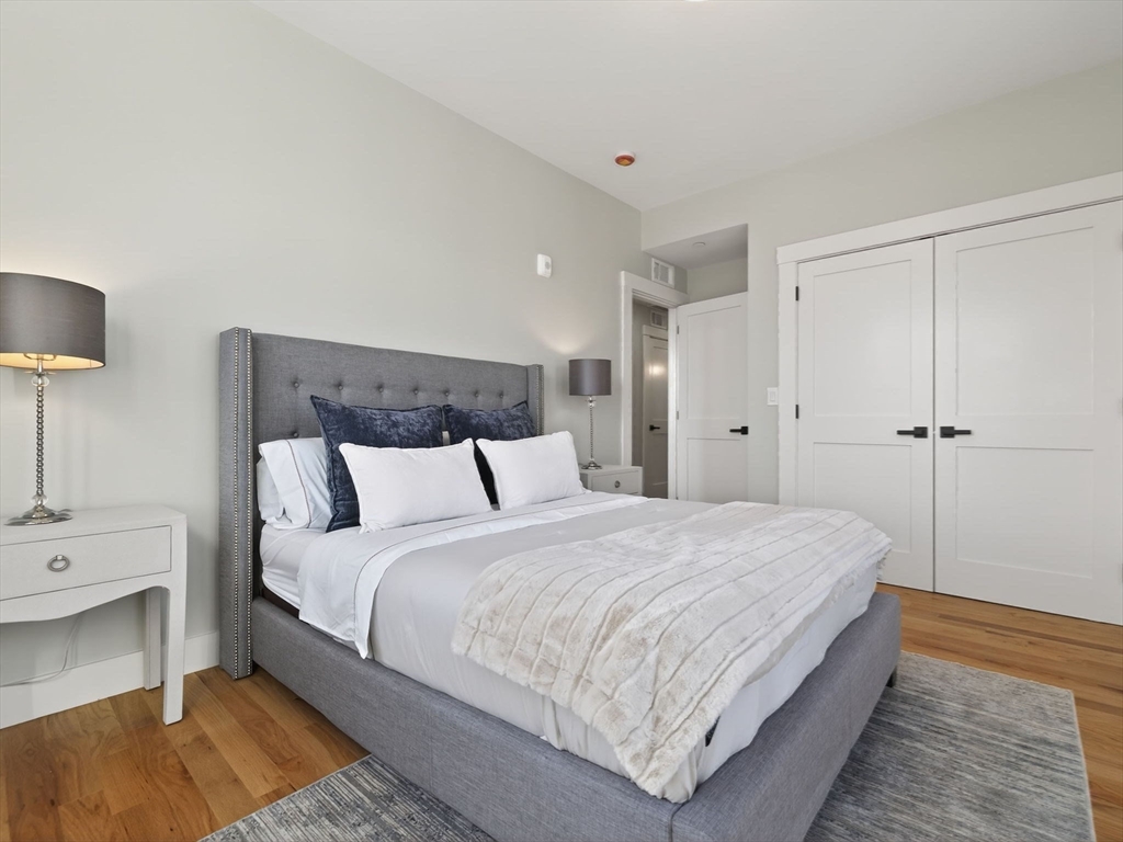 60 Stanley Street, Unit 203 Boston, MA 02125 - Photo 18 of 22 a bedroom with a bed and a night stand