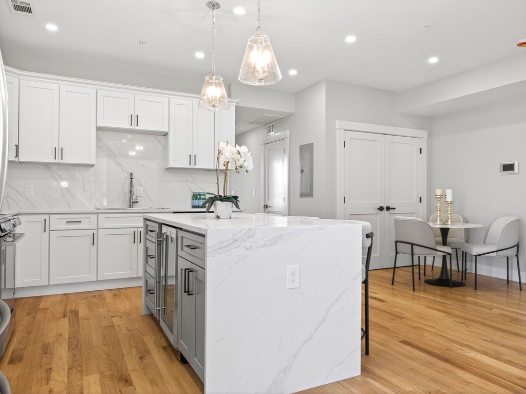 60 Stanley Street, Unit 203 Boston, MA 02125 - Photo 2 of 22 a kitchen with kitchen island a white counter top space cabinets and stainless steel appliances