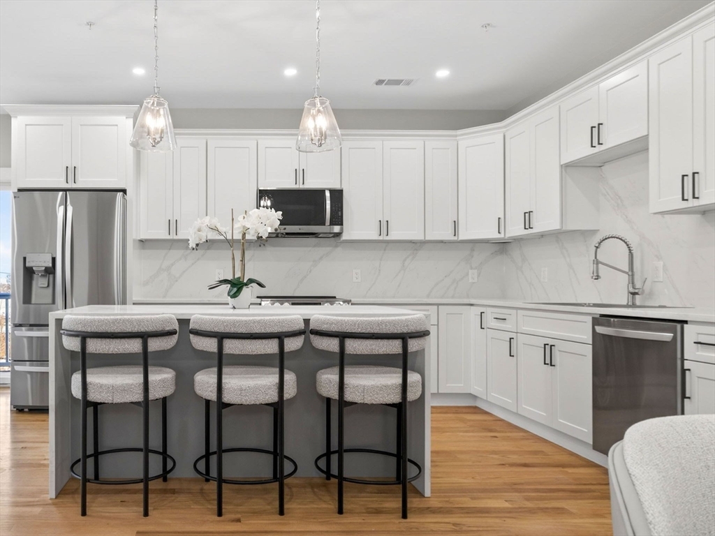 60 Stanley Street, Unit 203 Boston, MA 02125 - Photo 3 of 22 a kitchen with a sink cabinets and wooden floor