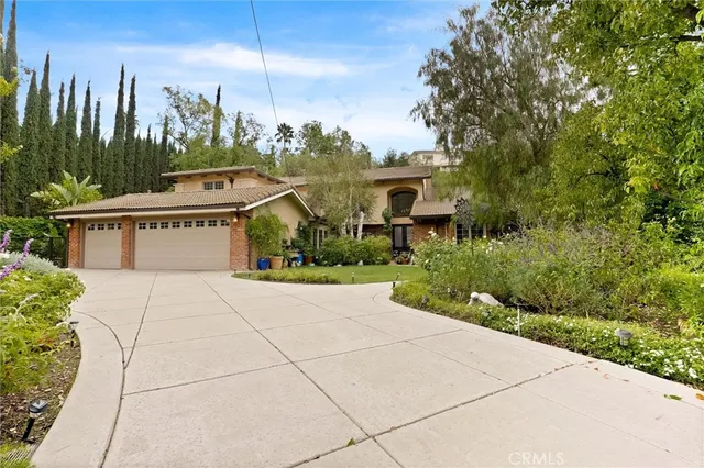a view of a house with a yard and potted plants