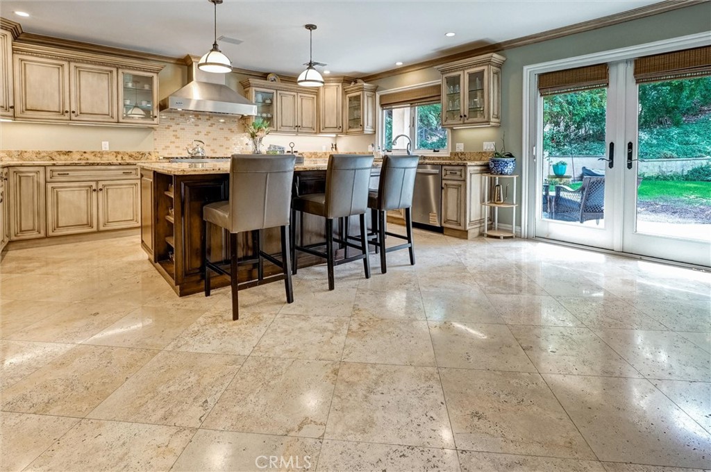 4751 Topeka Drive Tarzana, CA 91356 - Photo 16 of 65 a kitchen with kitchen island granite countertop wooden cabinets a counter top space and stainless steel appliances