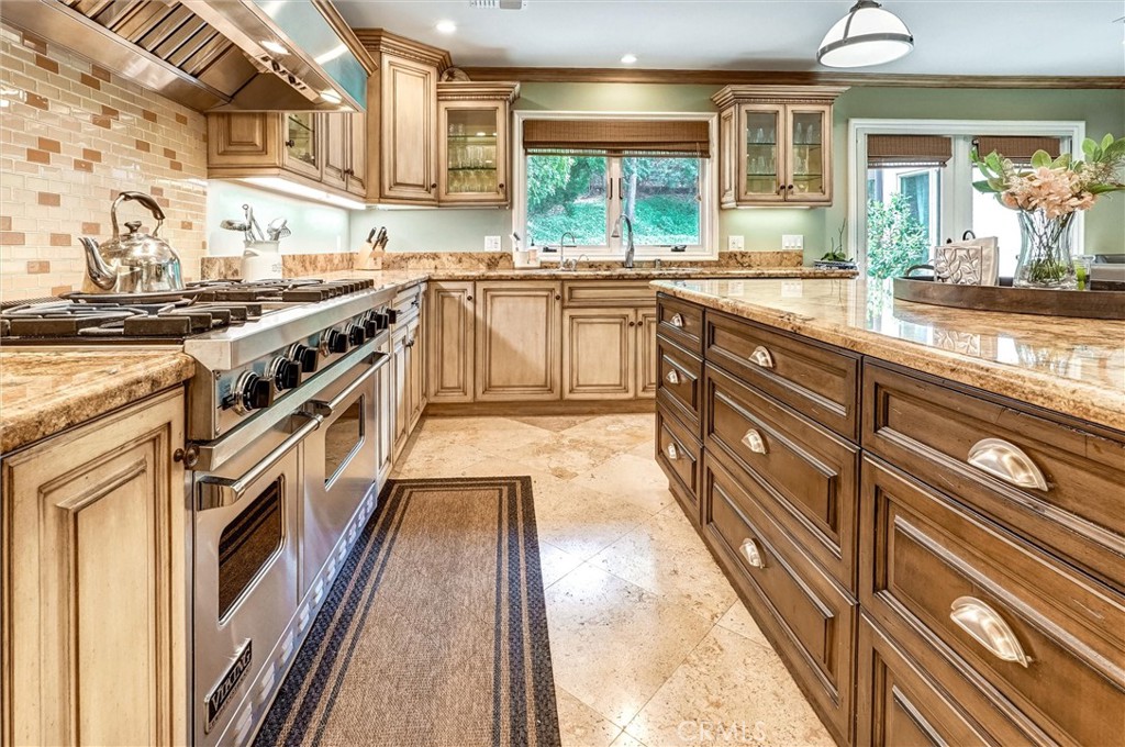 4751 Topeka Drive Tarzana, CA 91356 - Photo 18 of 65 a kitchen with stainless steel appliances granite countertop lots of counter top space and wooden floor