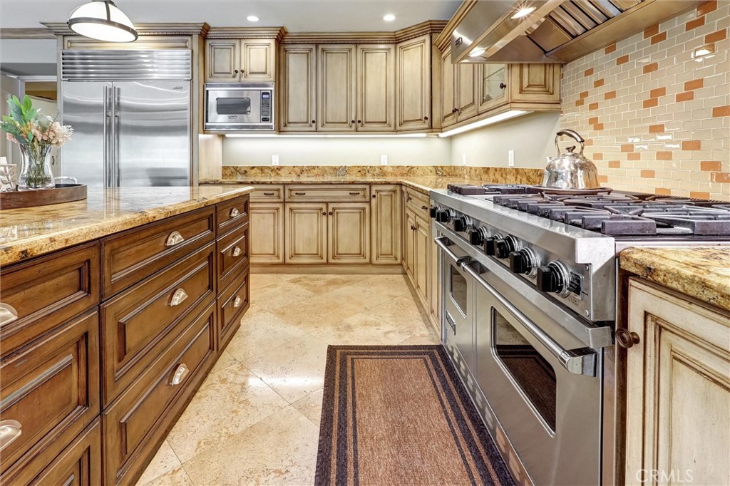 4751 Topeka Drive Tarzana, CA 91356 - Photo 19 of 65 a kitchen with stainless steel appliances granite countertop a stove and a sink