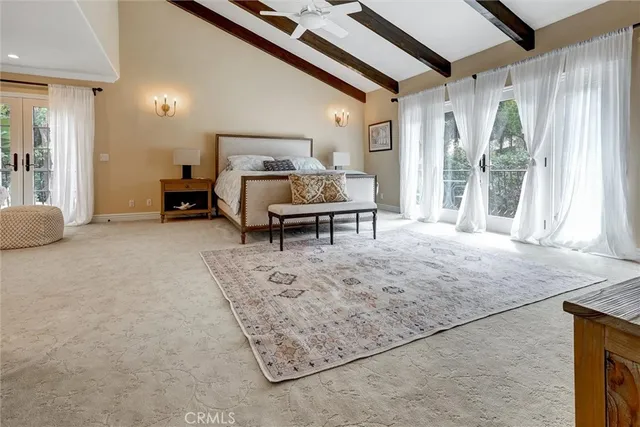 a spacious bedroom with a bed and a flat screen tv