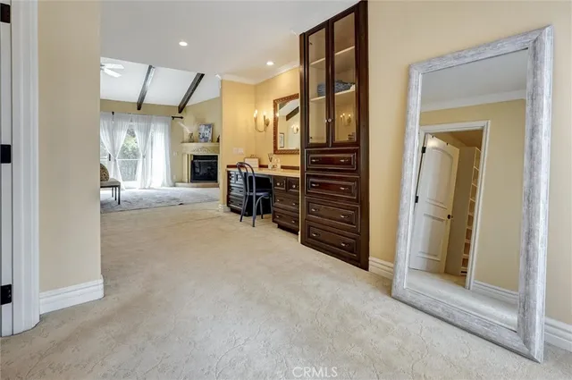 a spacious bedroom with a bed and a flat tv screen on dresser