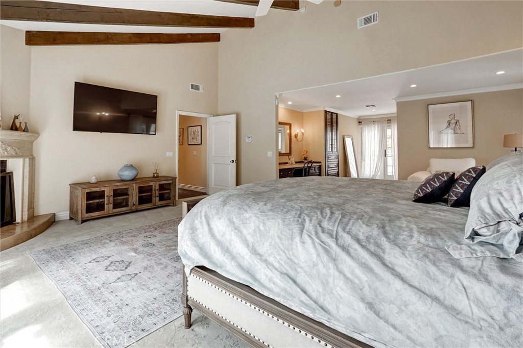 4751 Topeka Drive Tarzana, CA 91356 - Photo 40 of 65 a spacious bedroom with a bed and a flat screen tv