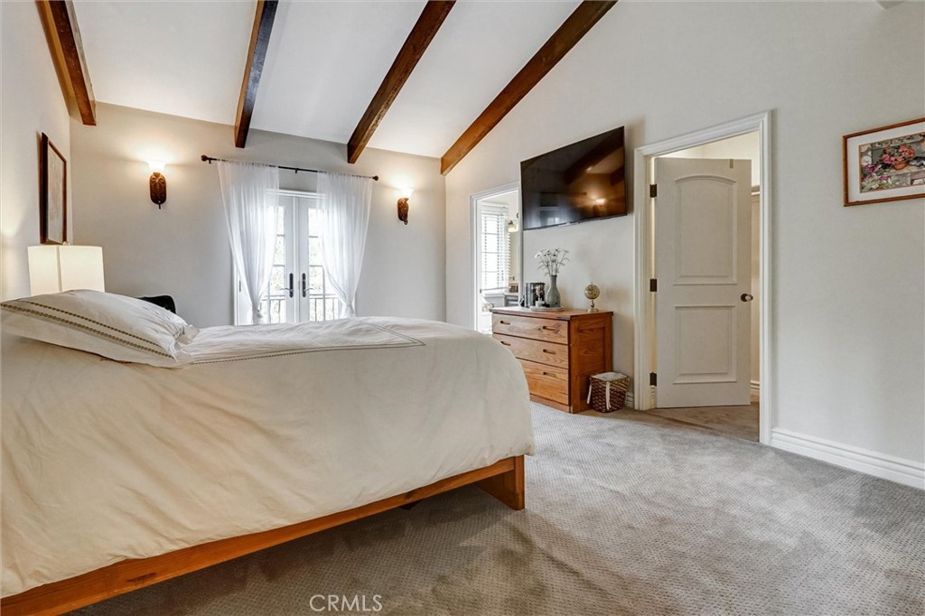 4751 Topeka Drive Tarzana, CA 91356 - Photo 43 of 65 a spacious bedroom with a bed and a flat tv screen on dresser