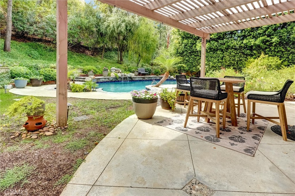 4751 Topeka Drive Tarzana, CA 91356 - Photo 64 of 65 a view of a patio with table and chairs potted plants with large tree
