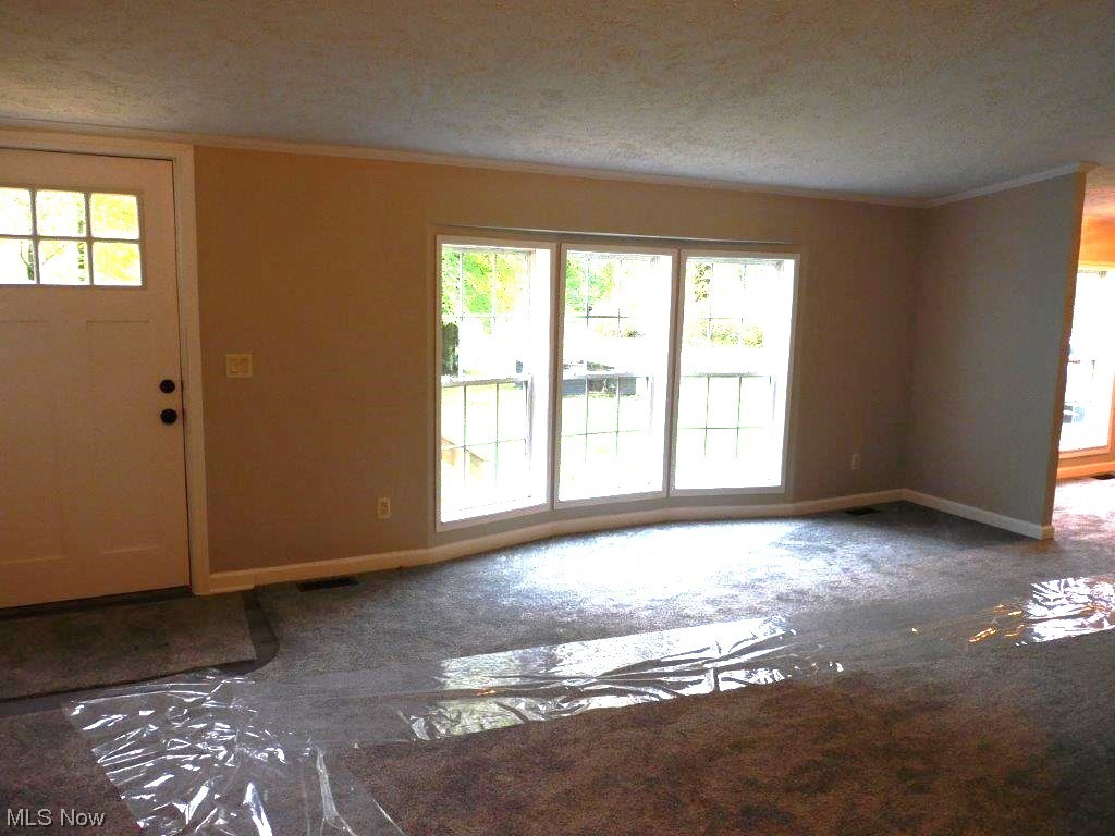 6045 Gore Road Ashtabula, OH 44004 - Photo 11 of 23 living room view C bay window featuring ornamental molding and a textured ceiling