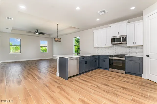 a kitchen with stainless steel appliances kitchen island granite countertop a stove a sink and a microwave