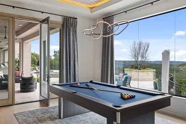 a dining hall with stainless steel appliances granite countertop a stove a sink a dining table and chairs with wooden floor