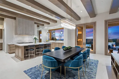 a large kitchen with sink a refrigerator and chairs