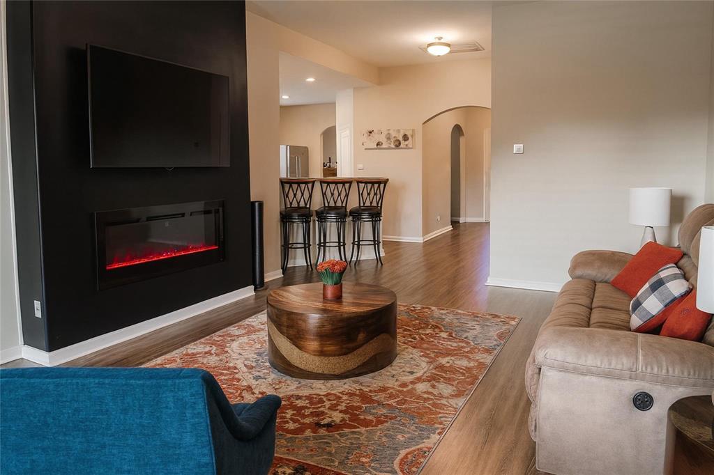 1837 Rialto Lane Crowley, TX 76036 - Photo 3 of 19 Living area featuring a modern black accent wall with an integrated electric fireplace