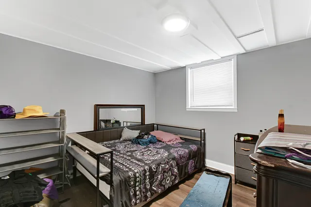 a bedroom with a bed and a lamp on the dresser