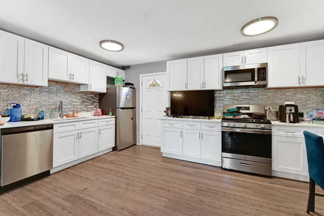 a kitchen with granite countertop white cabinets and stainless steel appliances