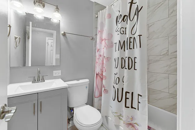 a bathroom with a sink a toilet and shower curtain