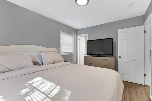 a bedroom with a large bed and a flat screen tv