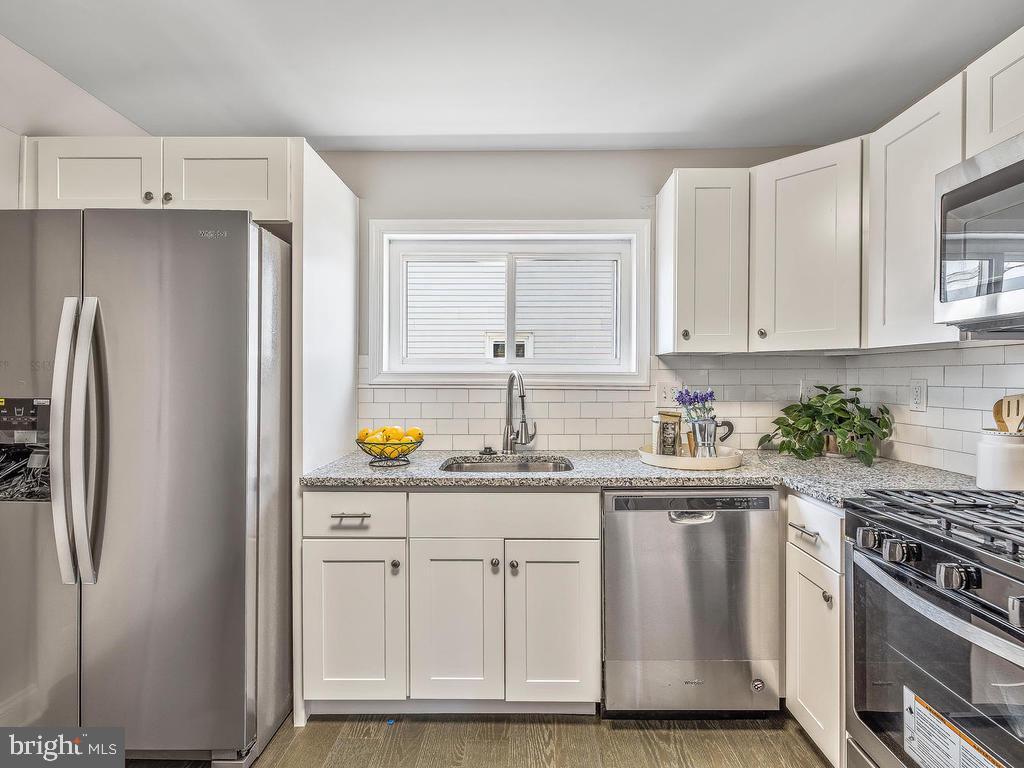 7718 Meath Road Dundalk, MD 21222 - Photo 11 of 27 a kitchen with stainless steel appliances granite countertop a refrigerator and a stove