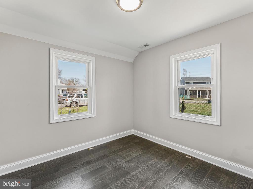 7718 Meath Road Dundalk, MD 21222 - Photo 18 of 27 a view of an empty room with a window and wooden floor