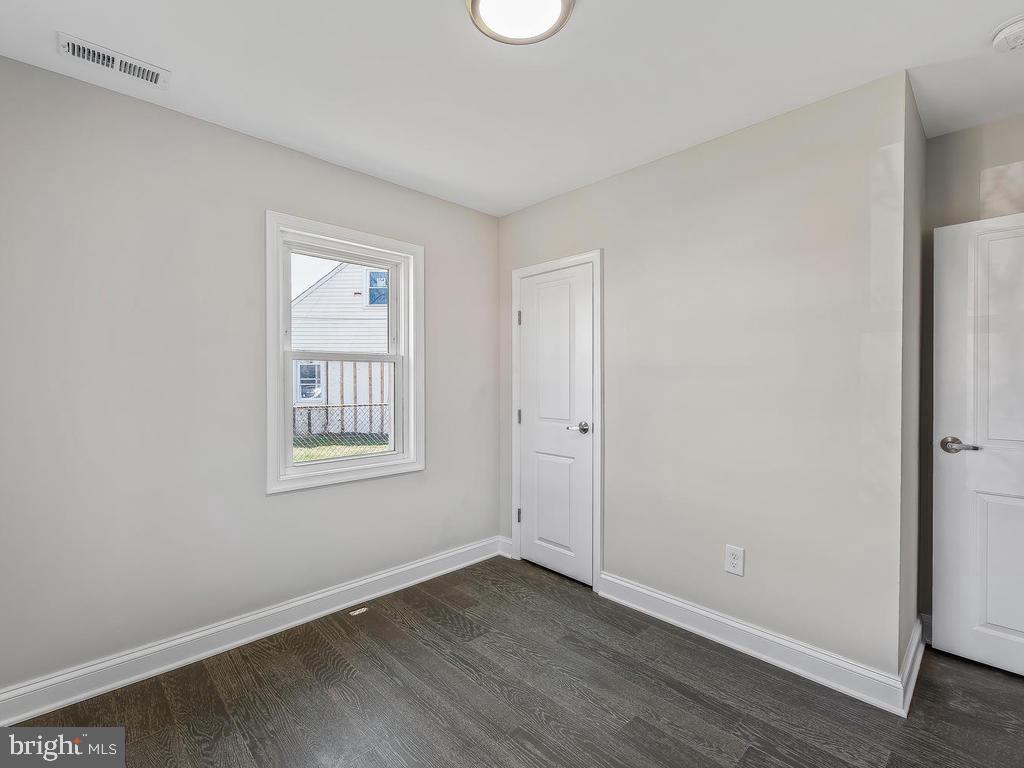 7718 Meath Road Dundalk, MD 21222 - Photo 19 of 27 an empty room with wooden floor and windows