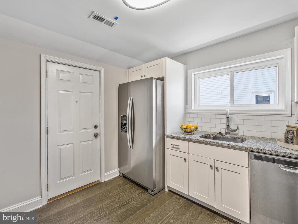 7718 Meath Road Dundalk, MD 21222 - Photo 10 of 27 a kitchen with stainless steel appliances granite countertop a refrigerator a sink and white cabinets