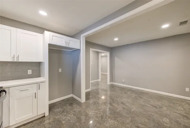 an empty room with cabinet and mirrors