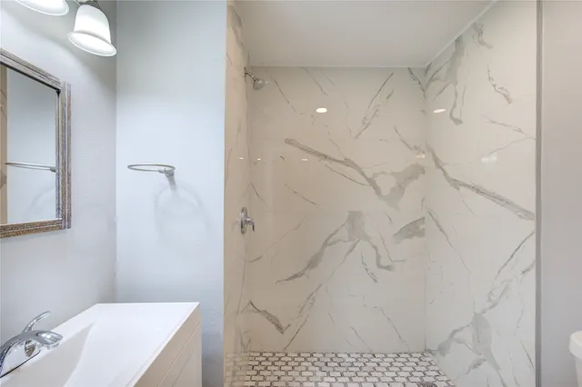 a bathroom with a sink vanity and shower