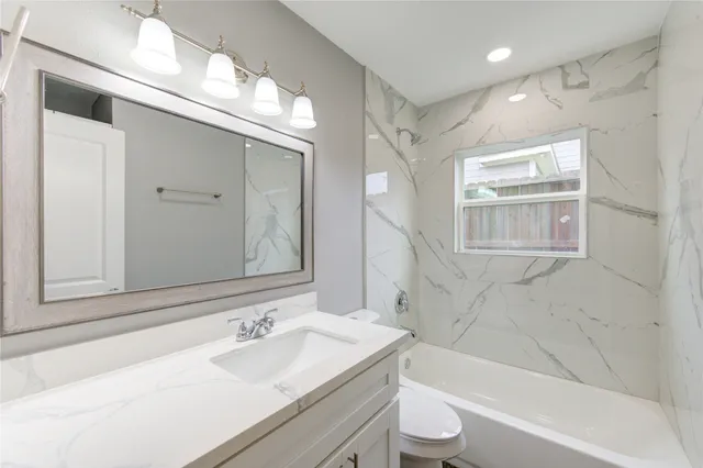 a bathroom with a sink toilet tub and shower