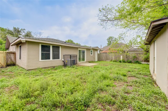 a view of backyard of house with deck and garden
